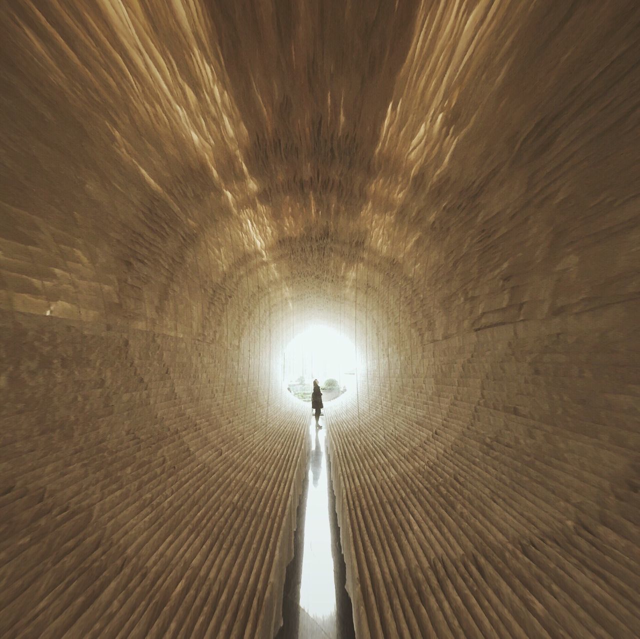 indoors, ceiling, tunnel, illuminated, architecture, built structure, lighting equipment, arch, the way forward, diminishing perspective, low angle view, pattern, vanishing point, circle, unrecognizable person, light at the end of the tunnel, famous place, men