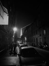 Cars on illuminated street in city at night