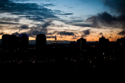 Silhouette buildings against sky at sunset