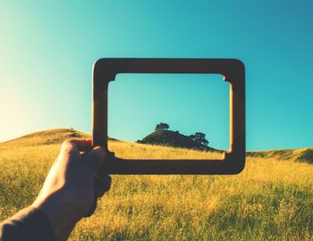 Man holding frame on grassy field