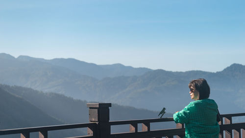 Rear view of woman walking on mountain against sky