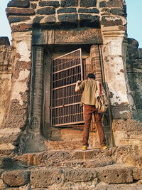 Full length of man standing against building