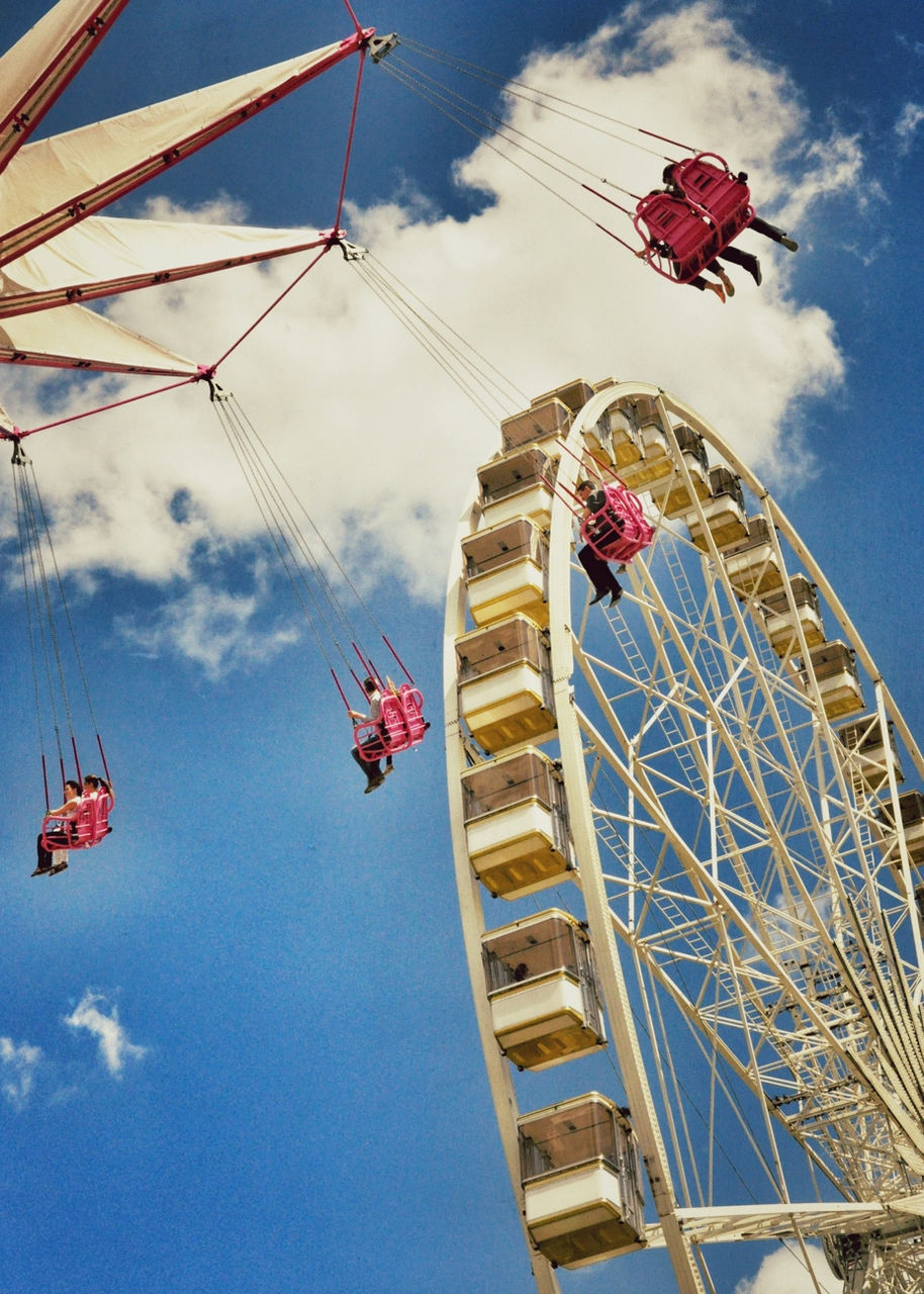 low angle view, amusement park ride, amusement park, ferris wheel, sky, arts culture and entertainment, cloud - sky, built structure, cloud, blue, day, architecture, fun, red, flag, outdoors, fairground ride, travel, no people, metal