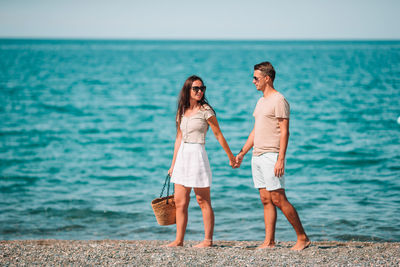 Woman standing on beach by sea