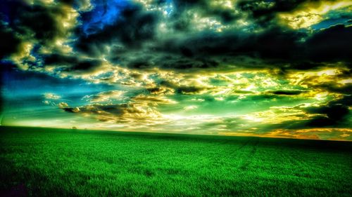 Scenic view of field against dramatic sky