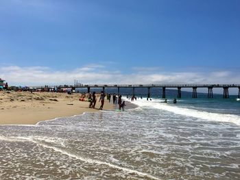 People at beach against blue sky