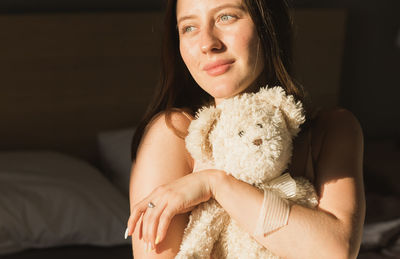 Portrait of young woman with stuffed toy