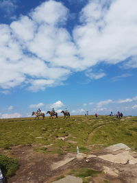 Group of people riding horses on landscape