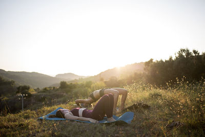 Man lying down on land against sky