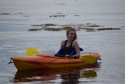 Girl kayaking on ocean in newfoundland, canada