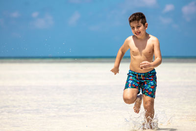 Portrait of shirtless man standing at beach