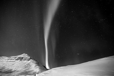 Scenic view of snowcapped mountain against sky at night