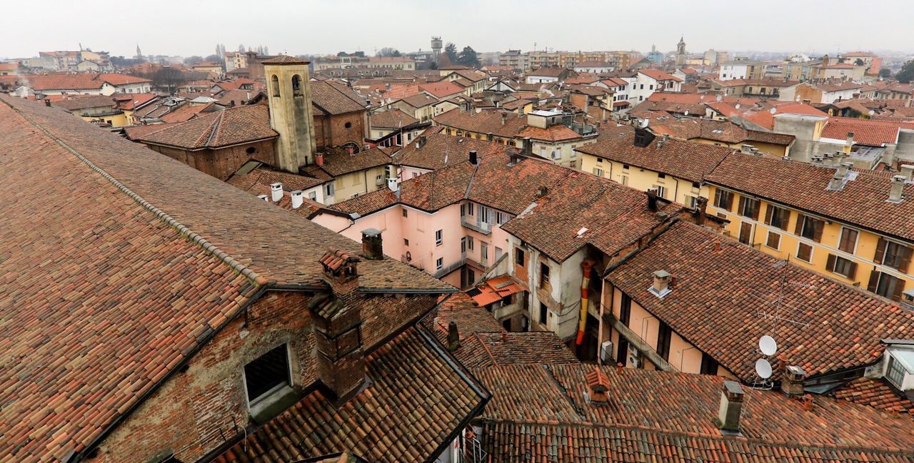 architecture, building exterior, roof, built structure, house, crowded, high angle view, day, residential building, outdoors, town, tiled roof, city, cityscape, gargoyle, sky