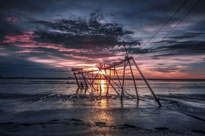 Scenic view of sea against dramatic sky during sunset