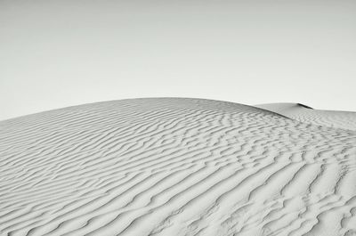 Sand dunes against clear sky