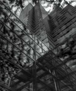 Low angle view of modern building against cloudy sky