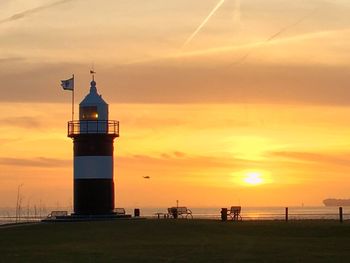 Lighthouse against sky during sunset