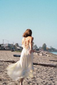 Side view of woman sitting at beach