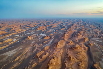 Aerial view of landscape and sea against sky during sunset