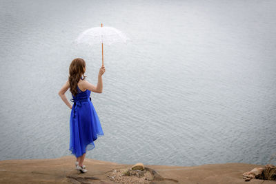 Woman with umbrella standing in water