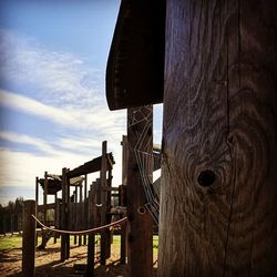 Wooden posts on field against sky