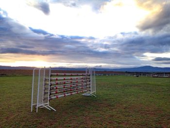 Scenic view of grassy field against cloudy sky