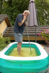 Man is cleaning the pool on a terrace