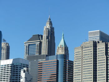 Low angle view of office buildings against clear blue sky