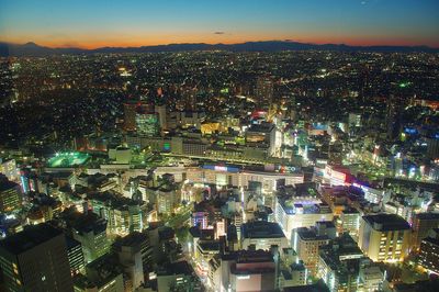 High angle view of illuminated cityscape of ikebukuro, tokyo against sky during sunset