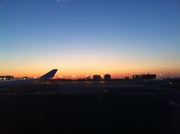 Illuminated cityscape against clear sky during sunset