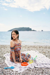 Full length of man sitting on beach