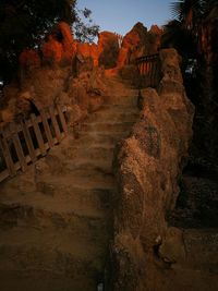 Walkway amidst trees against sky