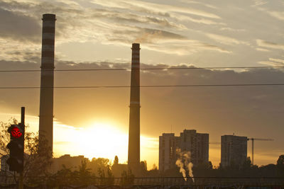 Silhouette buildings against sky during sunset in city