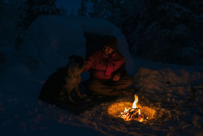 Mid adult man with dog sitting at campsite