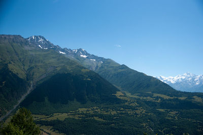 Scenic view of mountains against blue sky