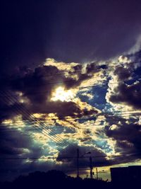 Low angle view of electricity pylon against cloudy sky