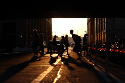 People crossing the street during sunset