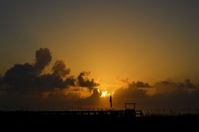 Silhouette beach against sky during sunset