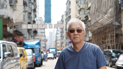 Portrait of man standing on street in city