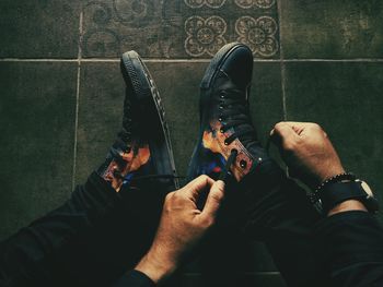 Low section of man sitting on tiled floor