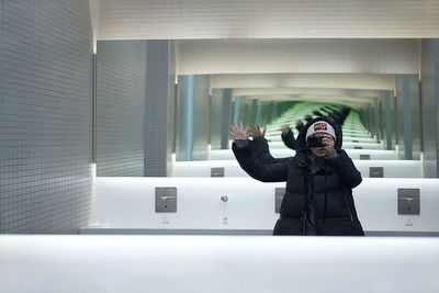 Woman taking mirror selfie in public restroom