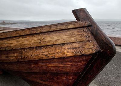 Close-up of old wooden boat at sea against sky