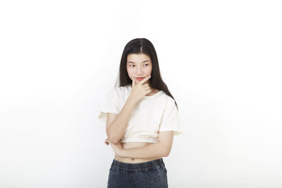 Portrait of woman standing against white background