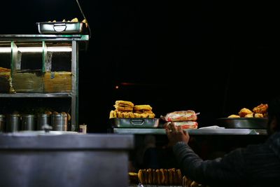 Man preparing food on display at night