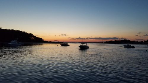 Scenic view of lake against clear sky at sunset