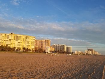 Beach by city against sky