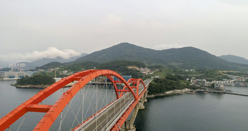 Bridge over river in city against sky