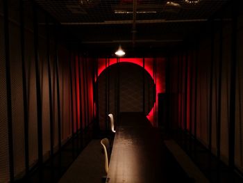 Rear view of man standing in illuminated tunnel