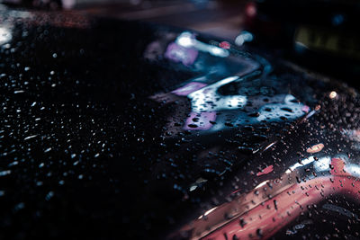 Close-up of raindrops on car windshield