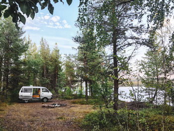 Car on field against trees in forest